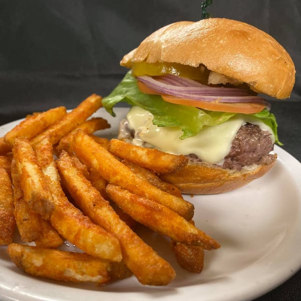 Hardy's catering burger with melted cheese, lettuce, tomato, onion, pickles, and a side of fries.