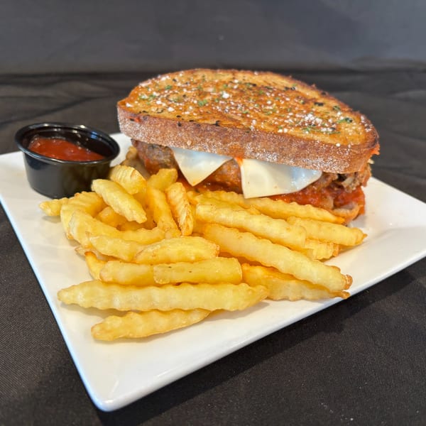Hardy's catering meatball sub with melted cheese, served with crinkle-cut fries and a side of ketchup.